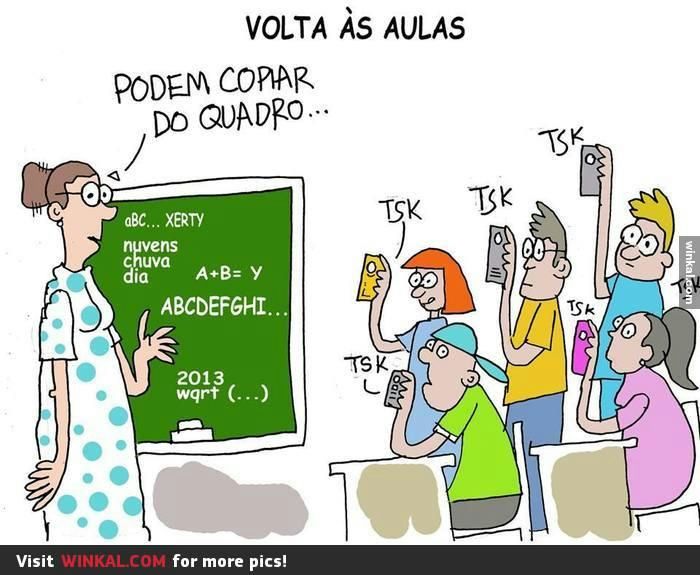 Uma professora em frente um quadro verde, com palavras escritas, dizendo aos alunos para copiarem